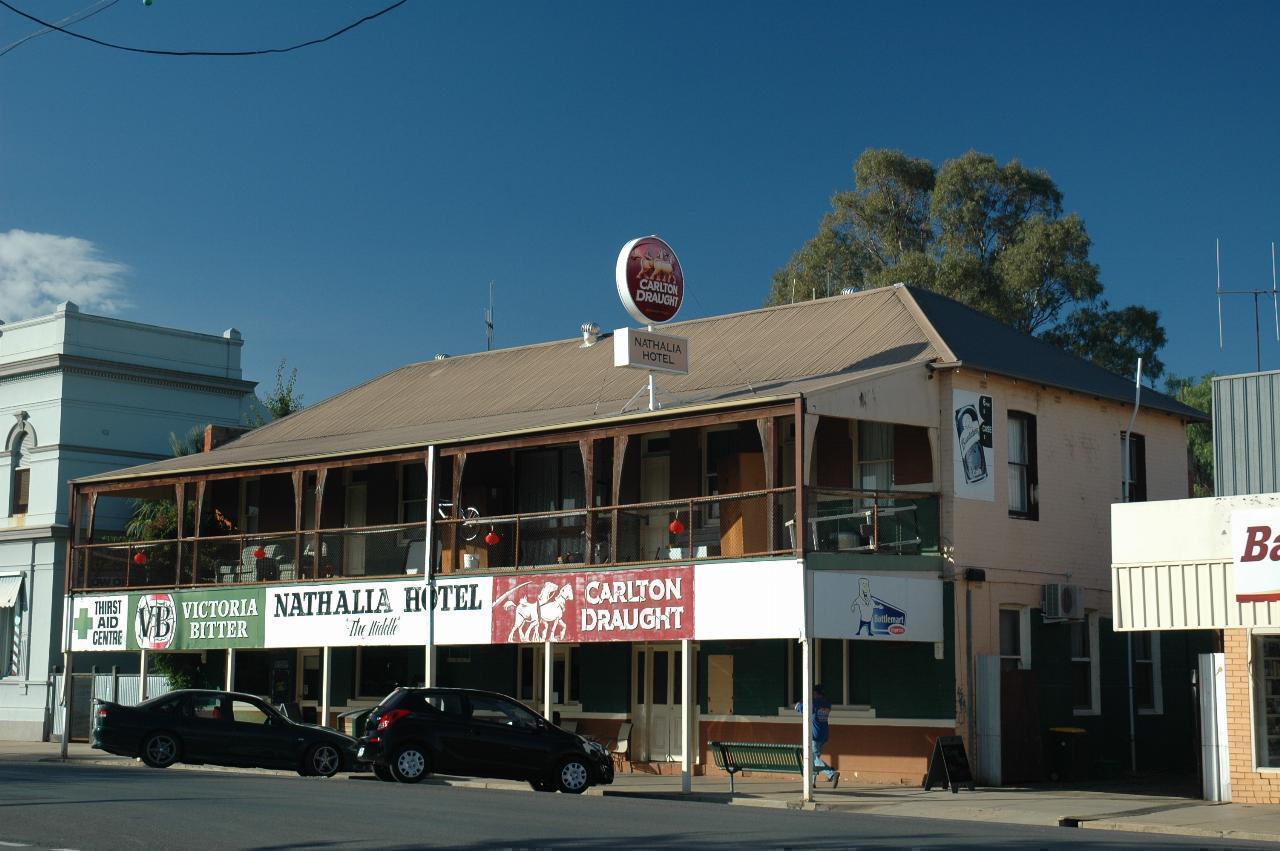Two storey building, with verandah, signs across the front