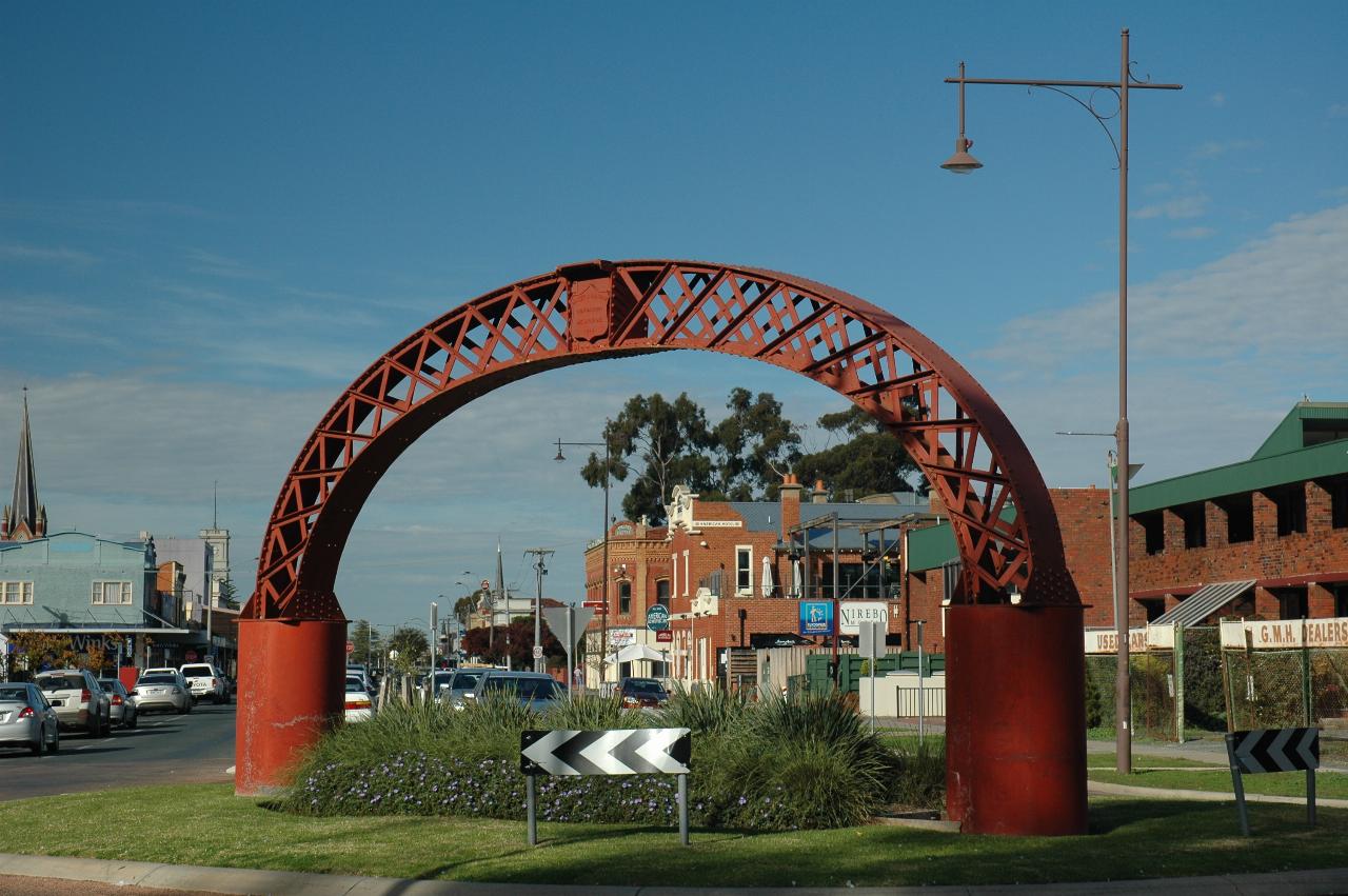 Roundabout with steel semi-circular truss from old bridge in middle of road