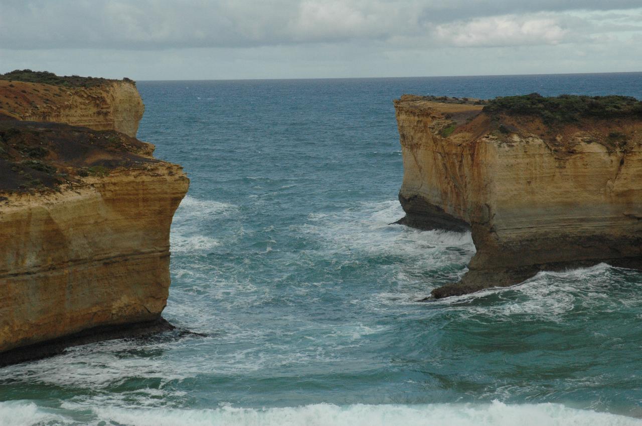 Two ochre coloured cliffs showing gap in former peninsula