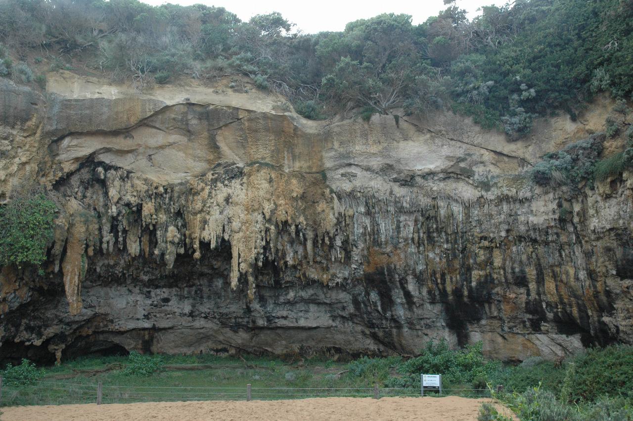 Cliff eroded at the base and with stalactites growing from the overhang
