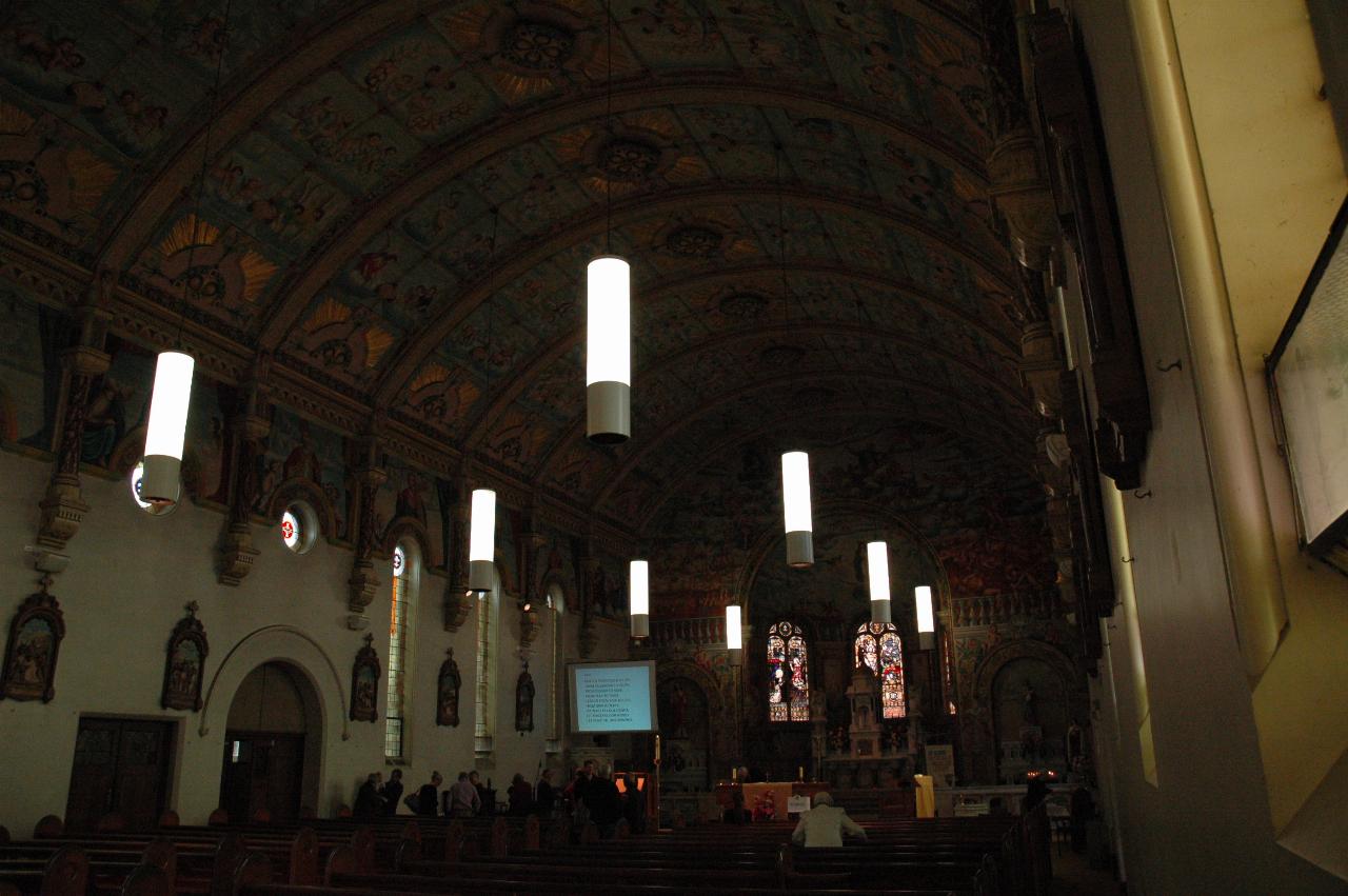 Looking from back of church towards front, high, semi-circular ceiling with rich decorations
