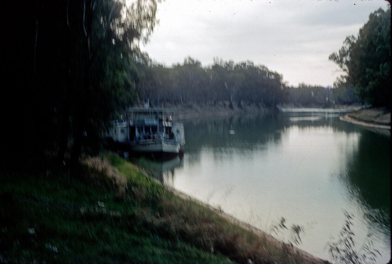 View along river with paddle wheeler tied to bank