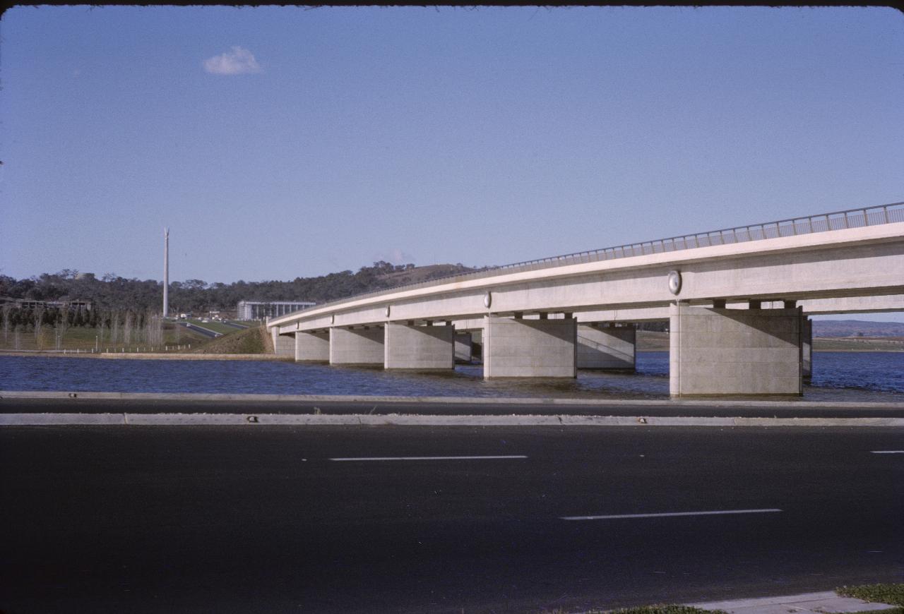 Parallel bridges over lake, leading to obelisk and buildings