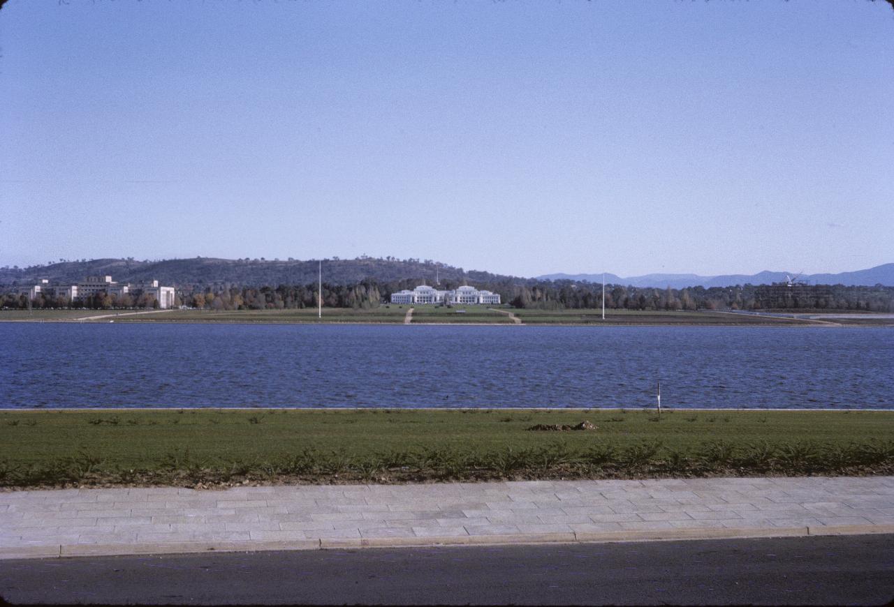 View across lake to white building and hill behind.