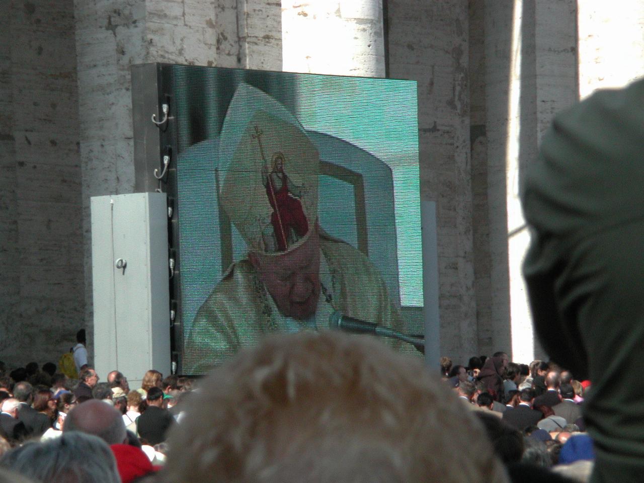 Pope John Paul II on the dias for canonisation Mass on TV screens