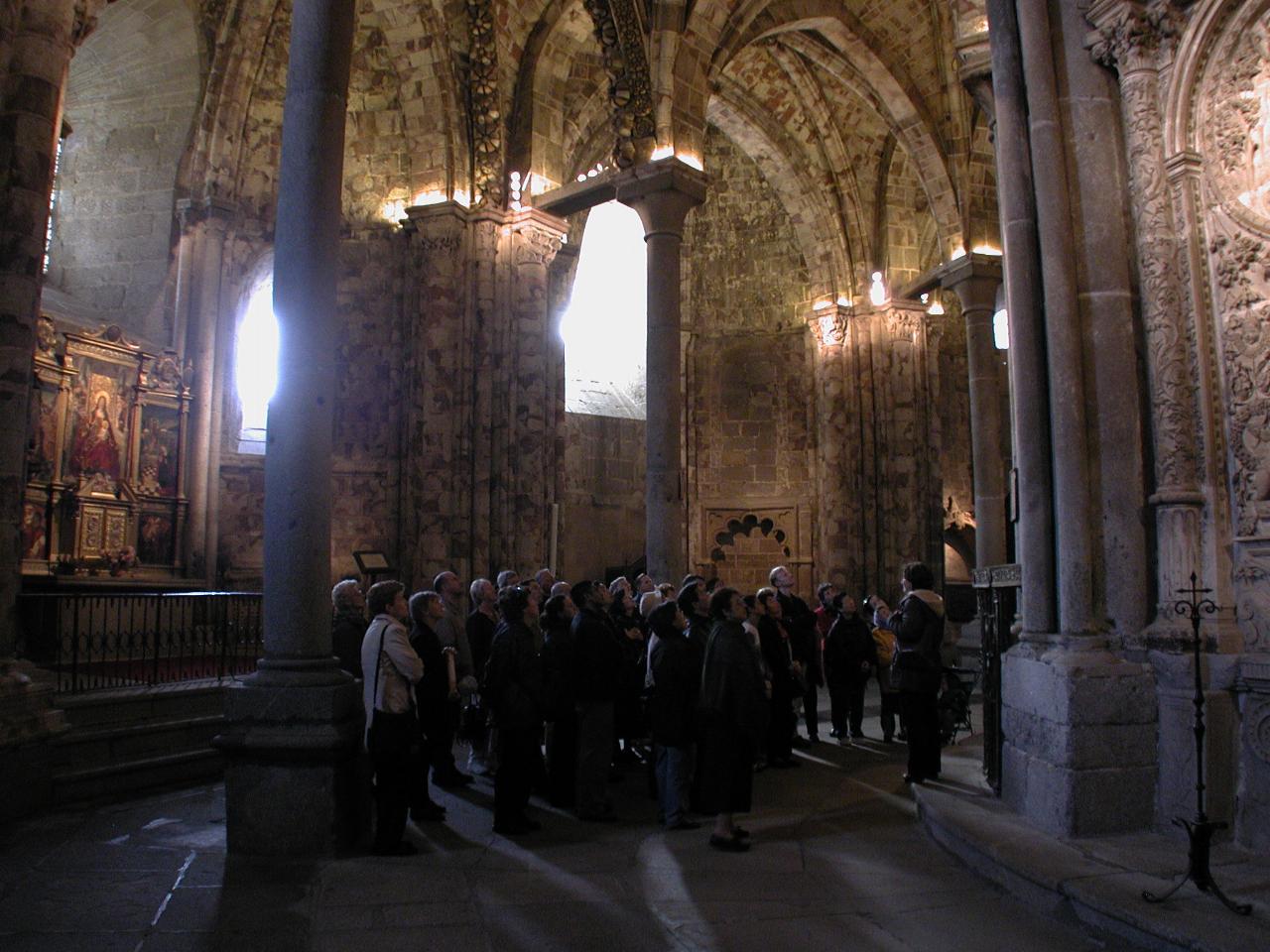 Tour group at old part of Avila Cathedral behind sanctuary