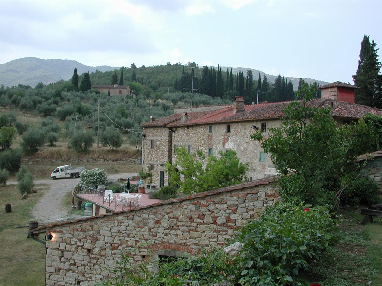 Castello del Trebbio wine store and nearby hills with olive trees