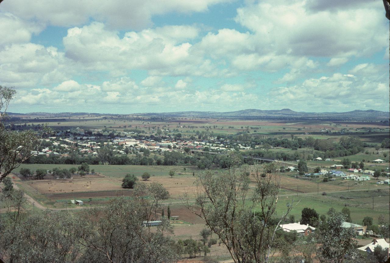 View from hill over small river to town and distant hills