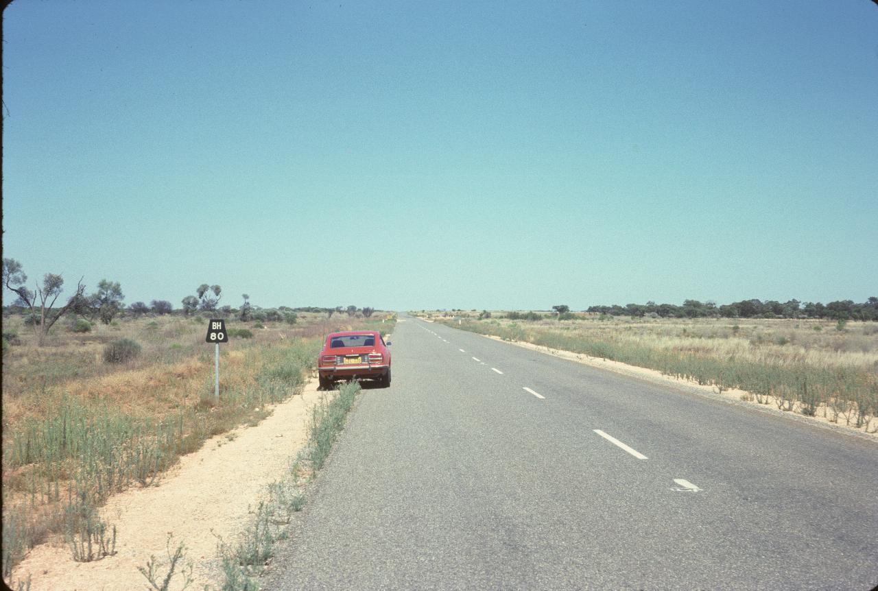 Car parked off road adjacent to 80 km to Broken Hill sign