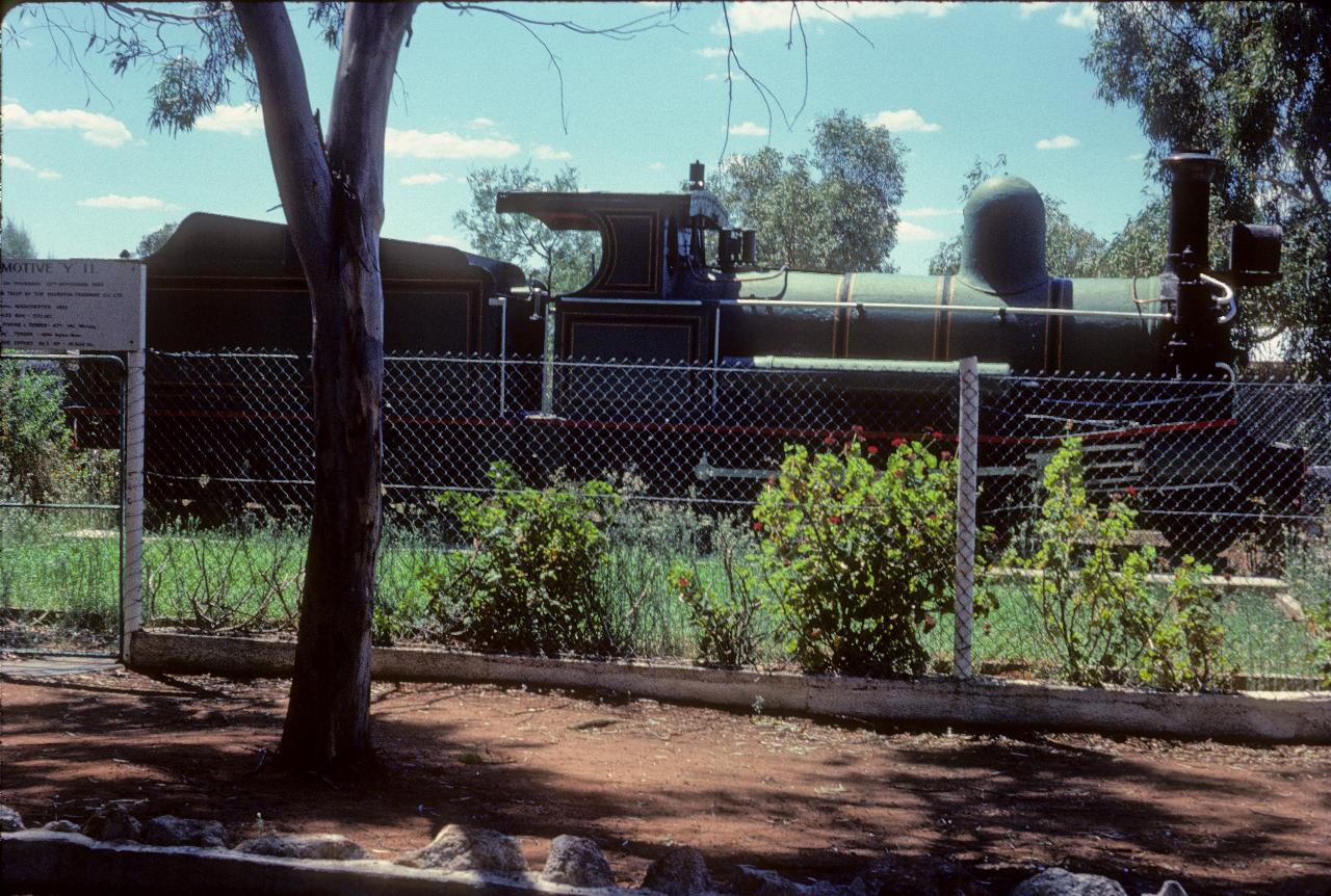 Restored steam locomotive behind wire fence