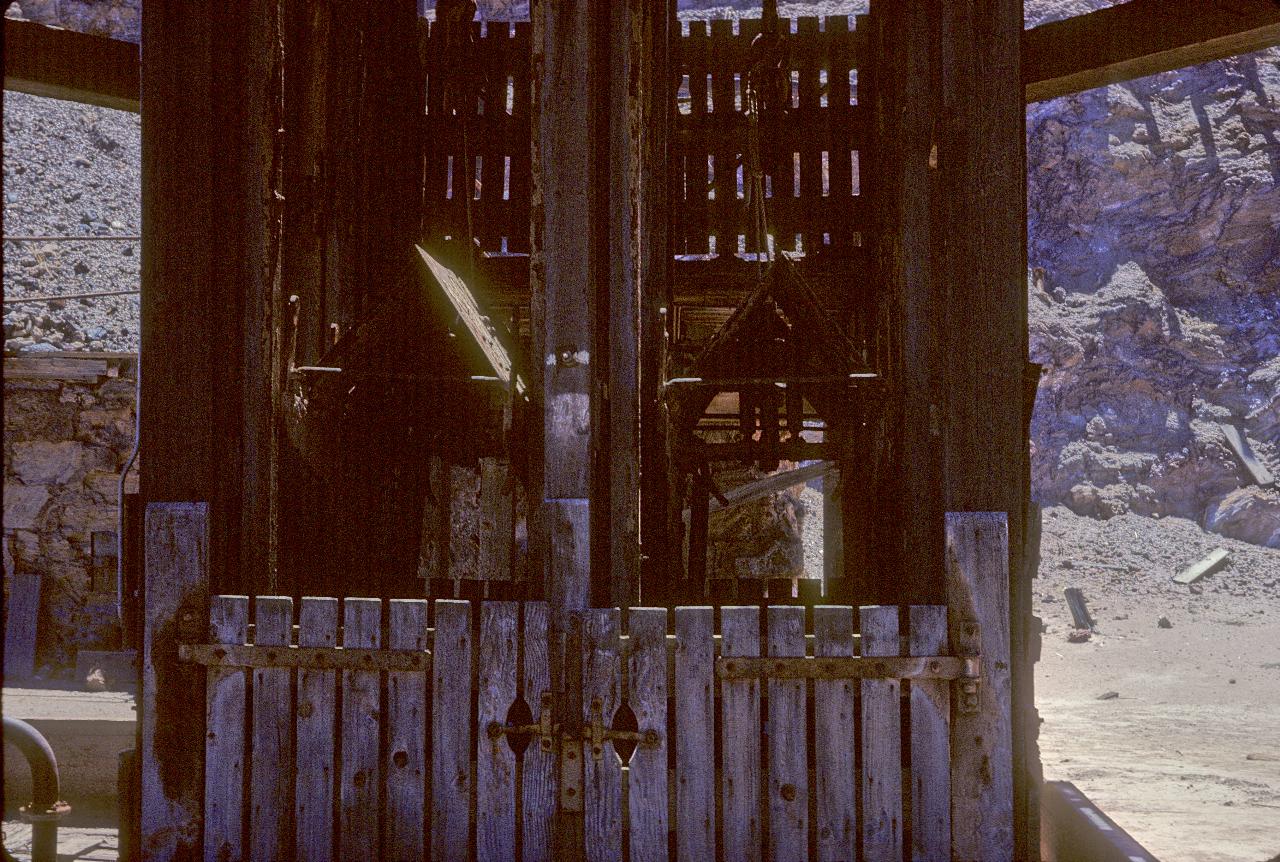 Wooden structure at top of shaft into mine, 2 wooden elevator cars in structure