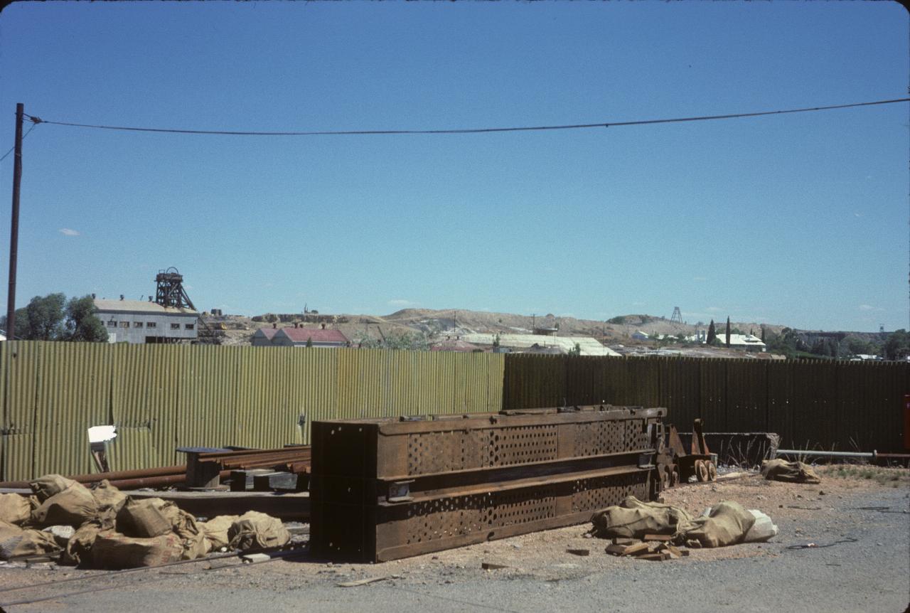 Distant hill with mining operations, foreground assorted mining pieces