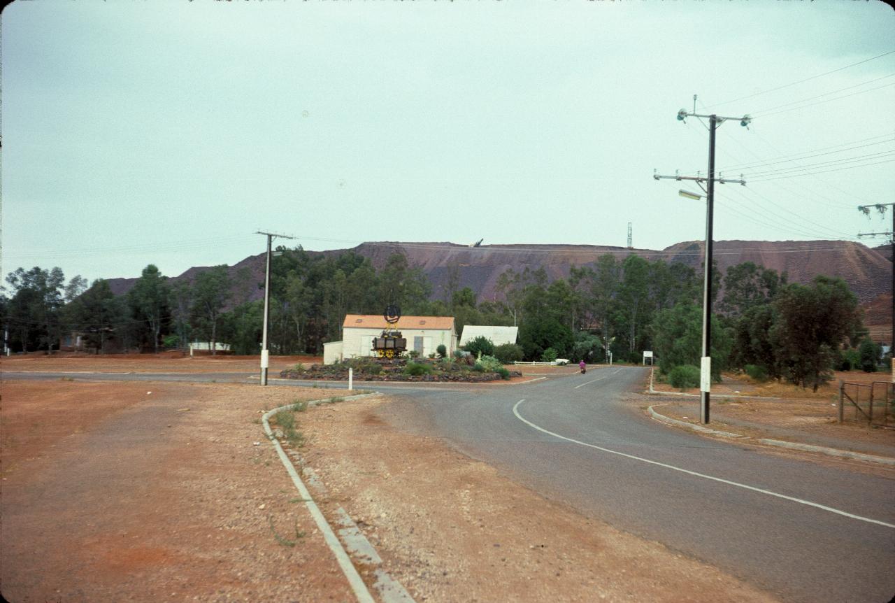 Quiet road with small hall and iron ore hill behind
