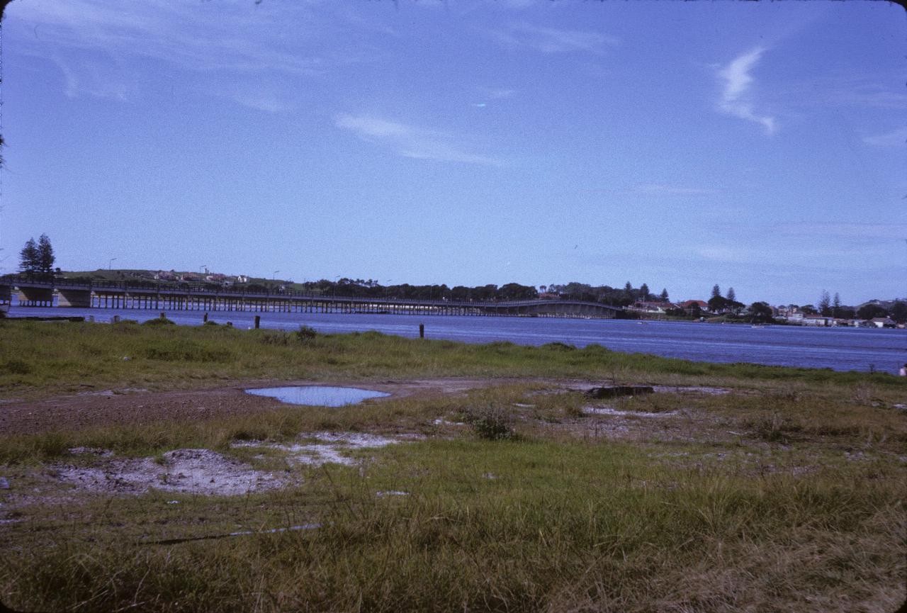 Long, low bridge on concrete piers, with a raised section at far end