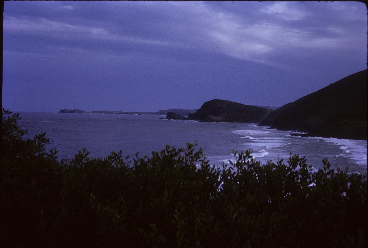 Heavy overcast sky, breakers and coastline extending south