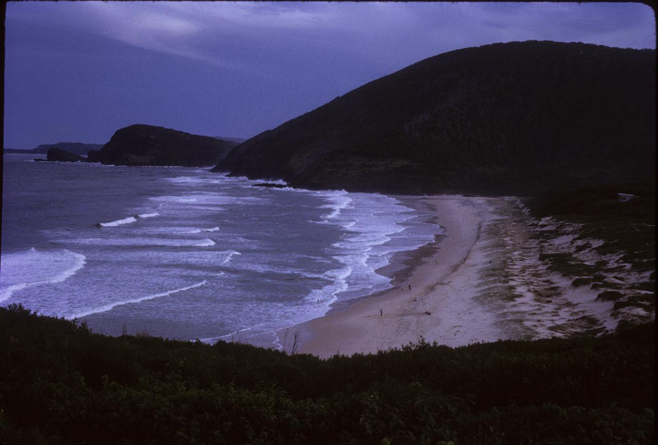 Heavy overcast sky, breakers and coastline extending south