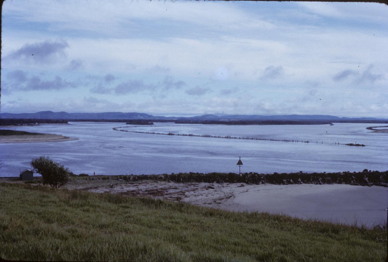 River with man made structures and distant hills