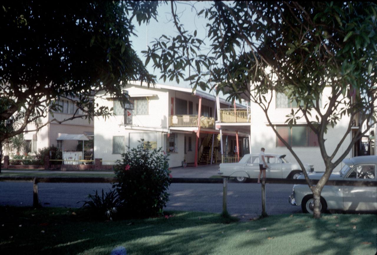 View between trees across road to 2 storey motel