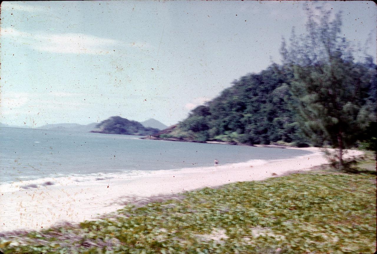 Ocean beach to headland with distant mountains