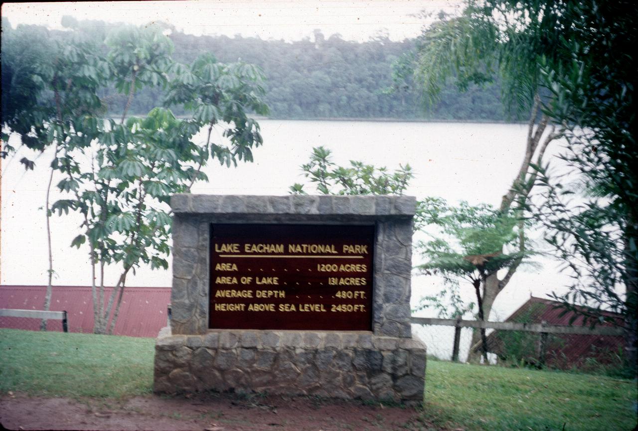 Sign for Lake Eacham and volcanic lake behind