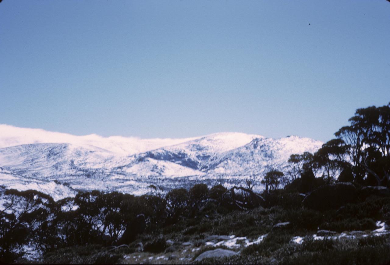 Light snow covering on hills and trees in foreground