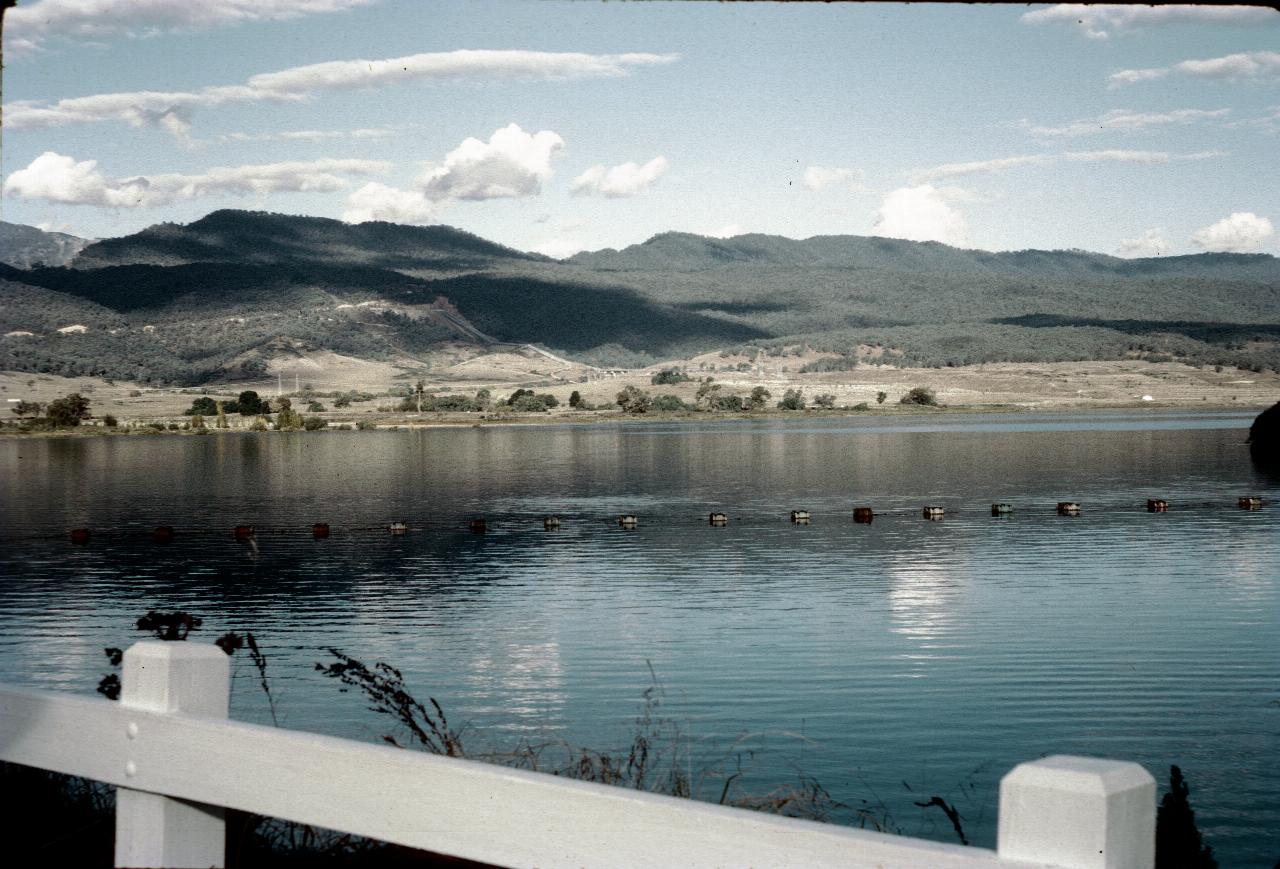 Lake with debris barrier and distant hills