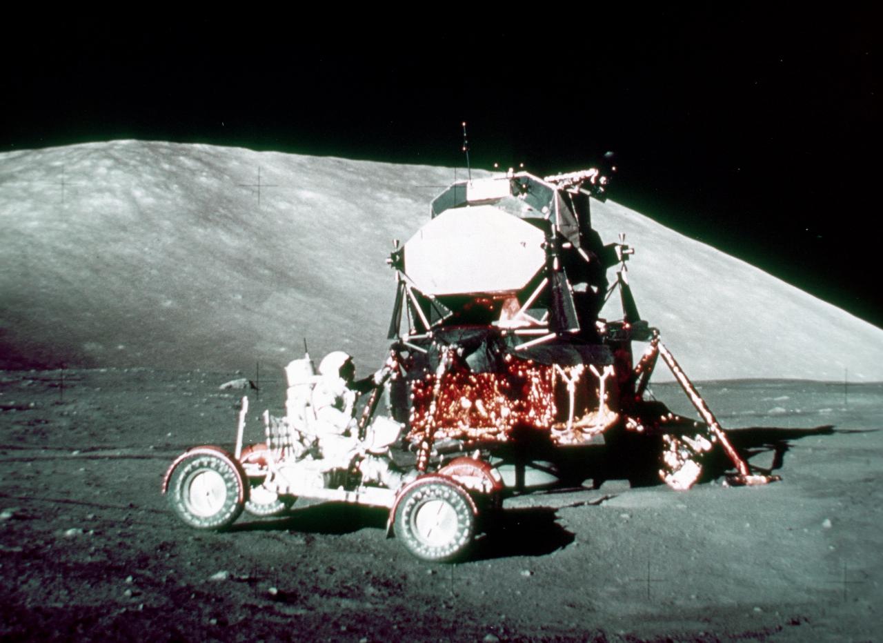 Rover with astronaut in front of lunar module