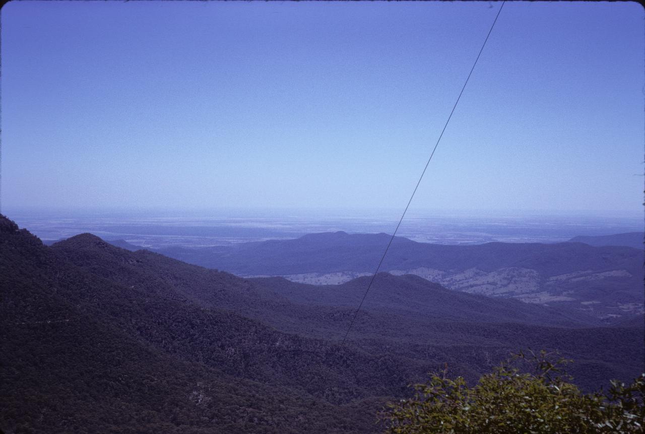 View from mountain over lower hills to plains into the distance