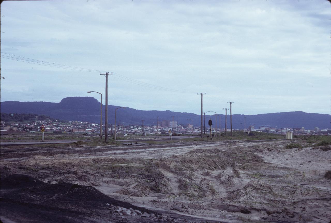 Looking over sand, across smaller city to distant hills