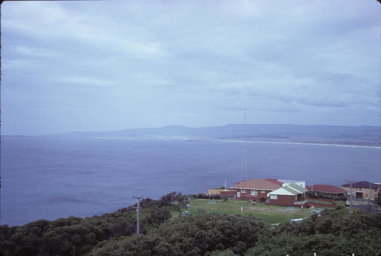 Nearby house, wide open ocean and distant beach and hills