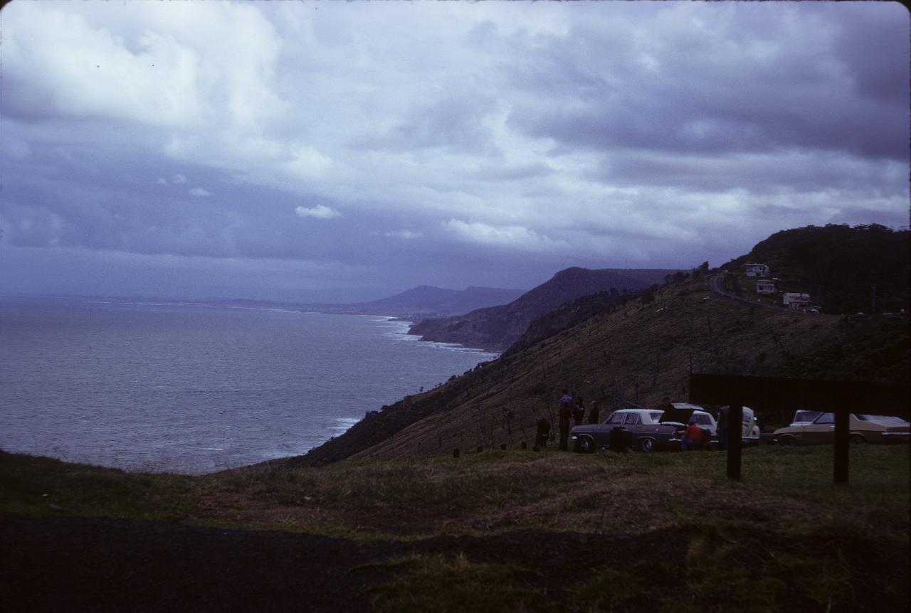 High view down coastline with breaking surf and dark clouds