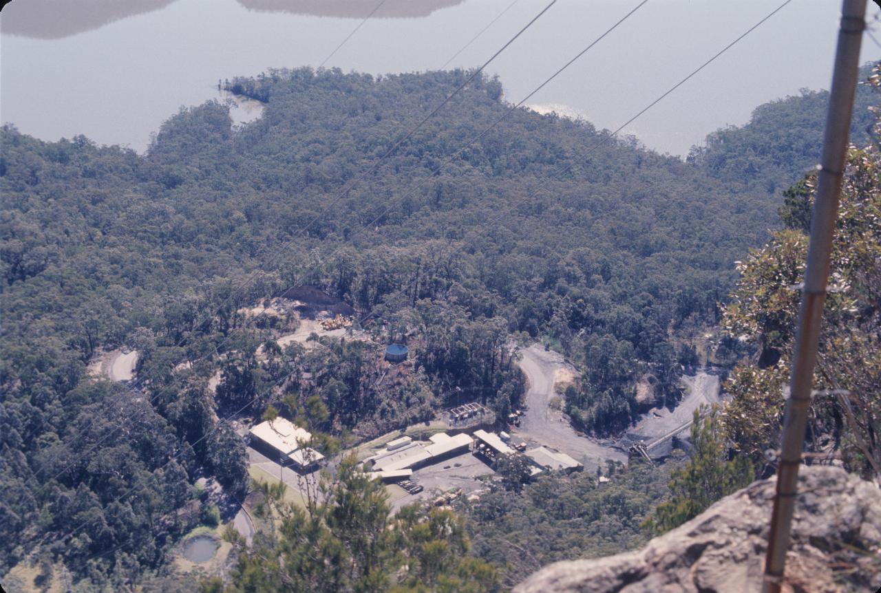 Several buildings in bushland directly below the cliff