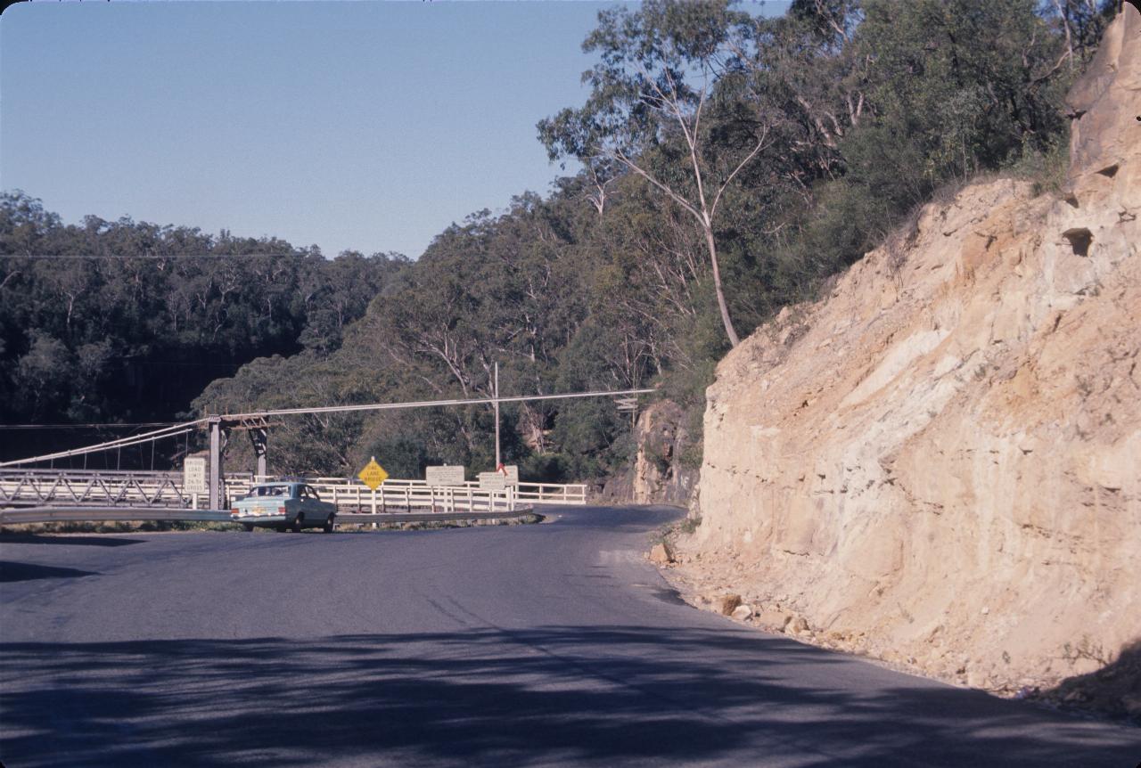 Other end of suspension bridge, showing cables tied to rocks