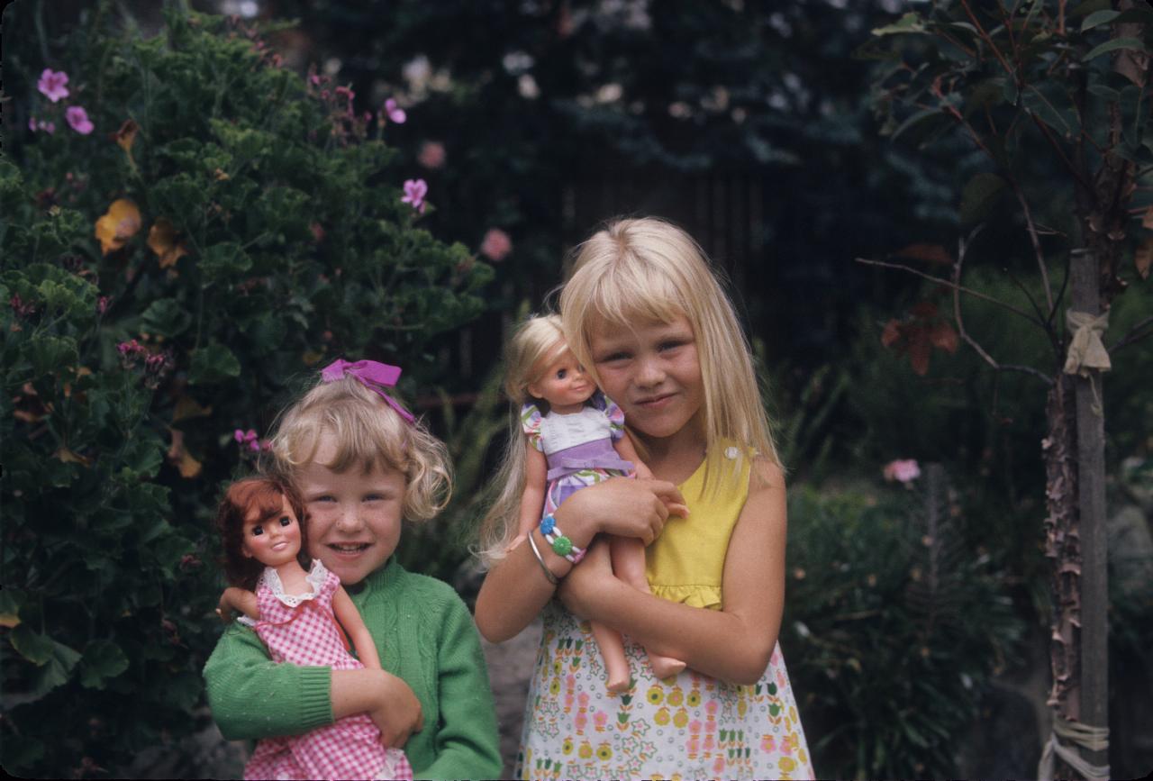 Two little girls holding dolls