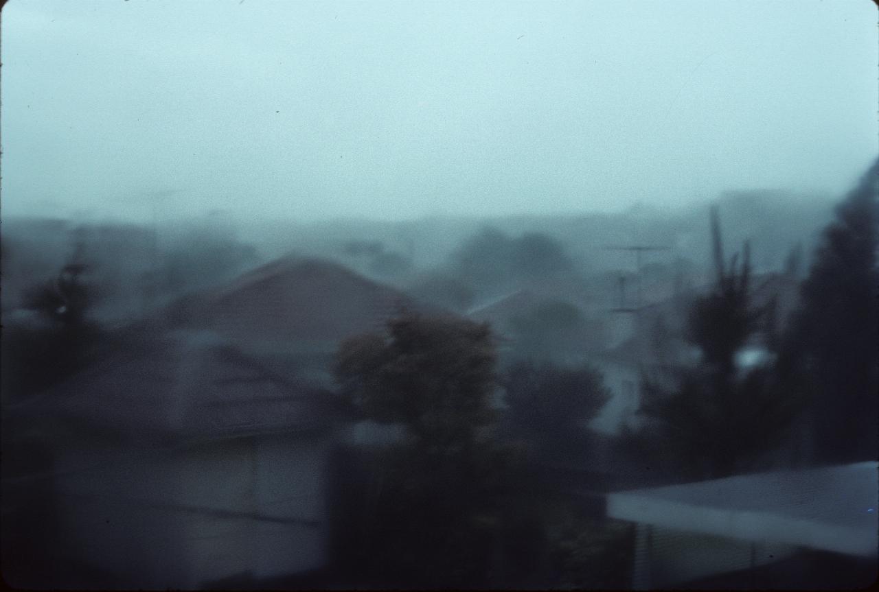 Suburban scene looking over roofs, but blurred due to rain