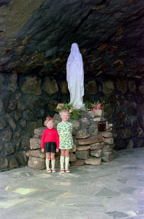 Two little girls in front of statue in rock grotto