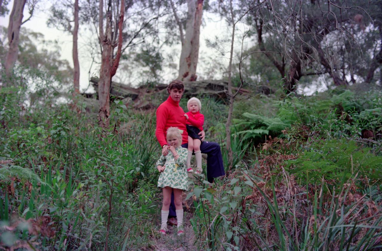 Father and 2 daughters on bush track below rocks