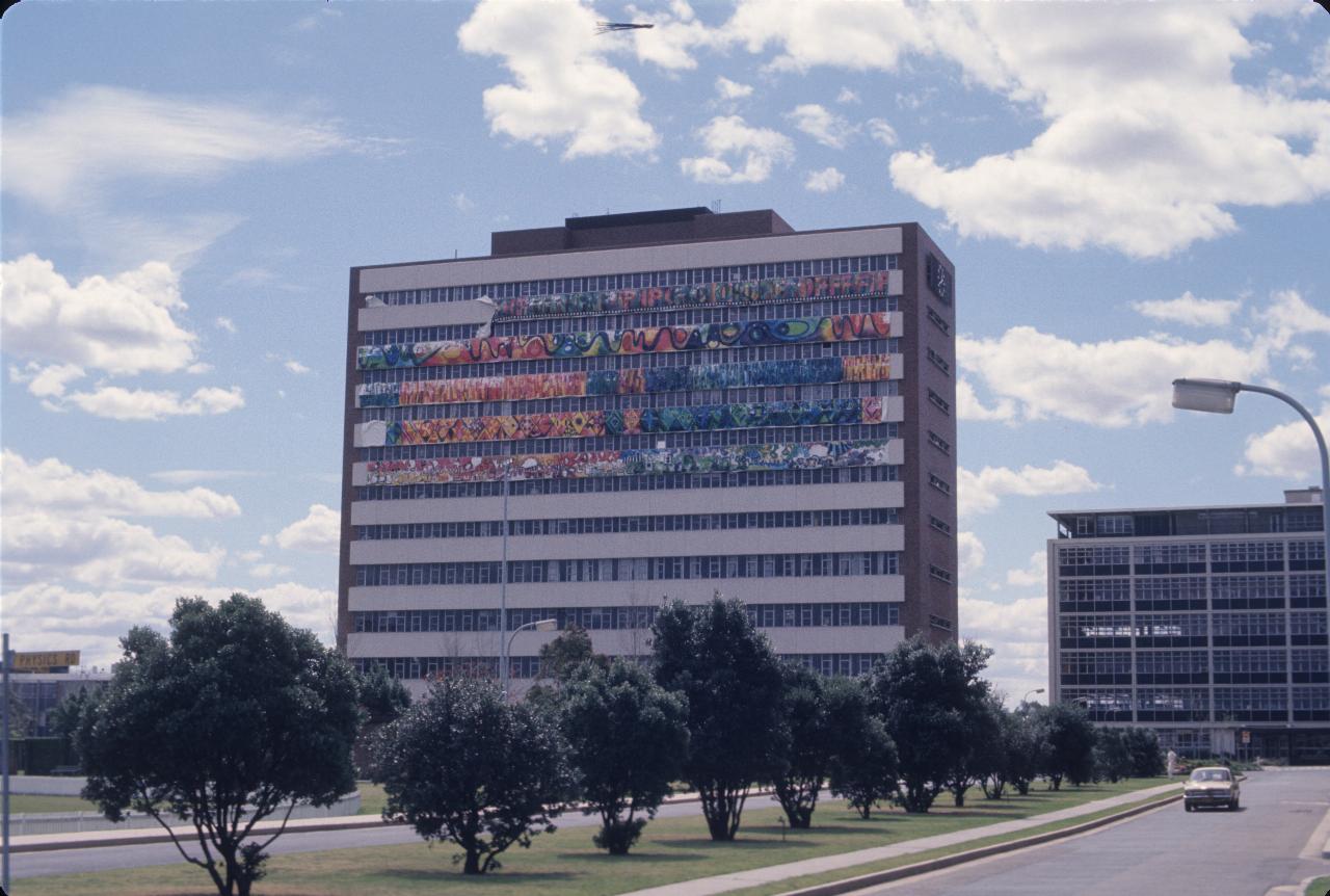 10 storey building, white panels on side, some decorated