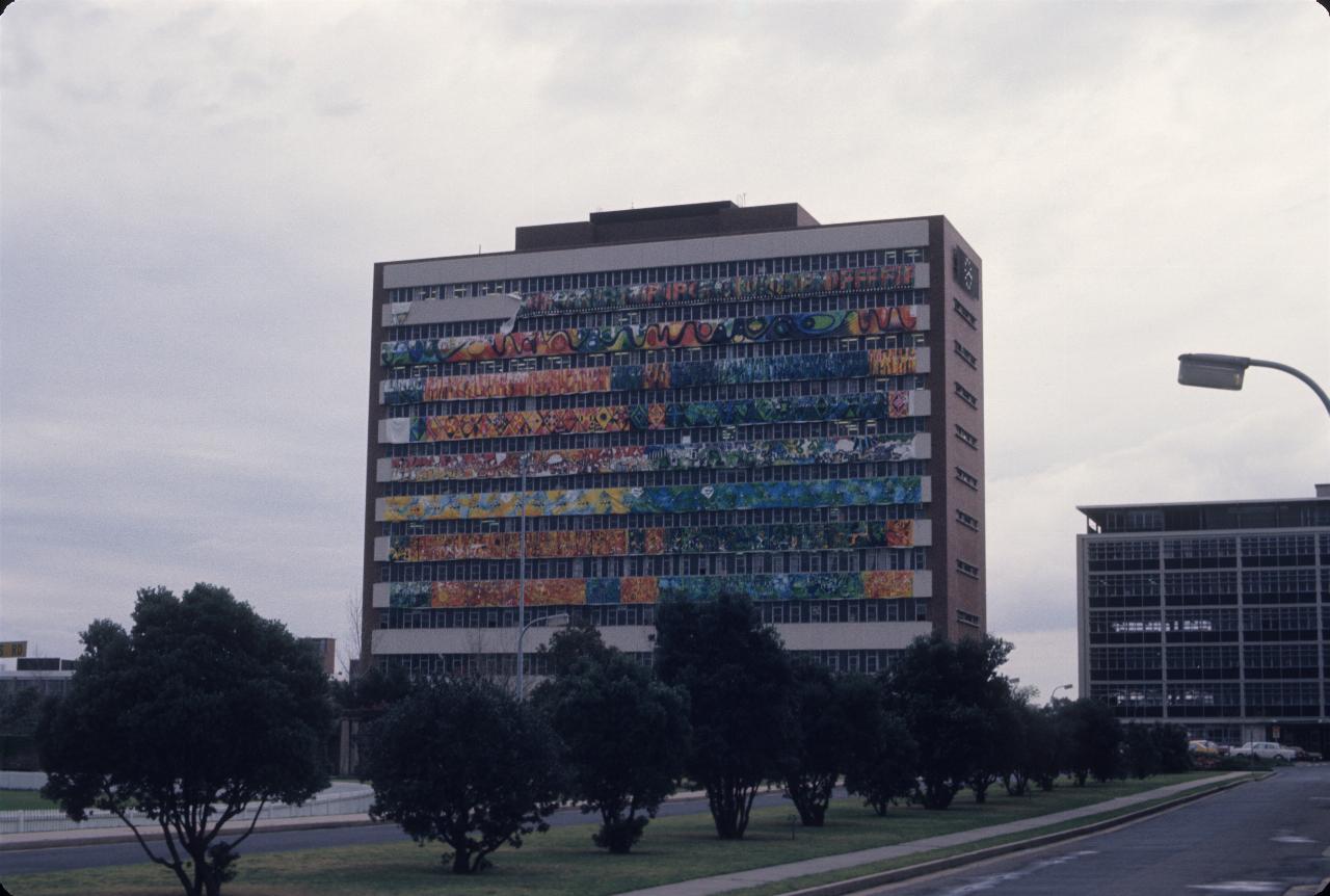 10 storey building, white panels on side, some decorated