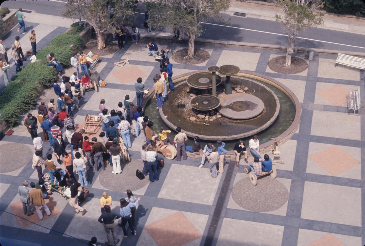 Plaza with fountain, students and wooden vehicles