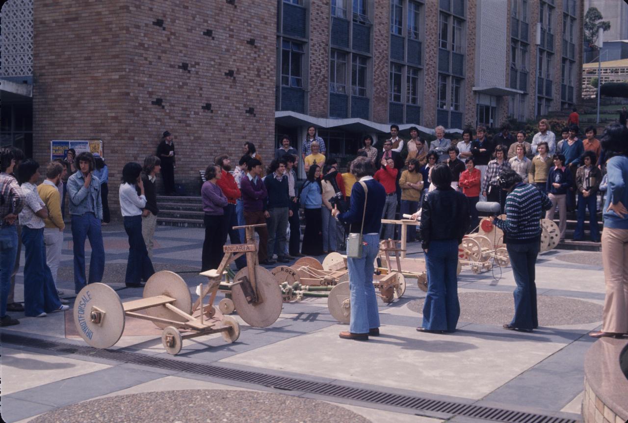 Several cars and students as seen on the plaza