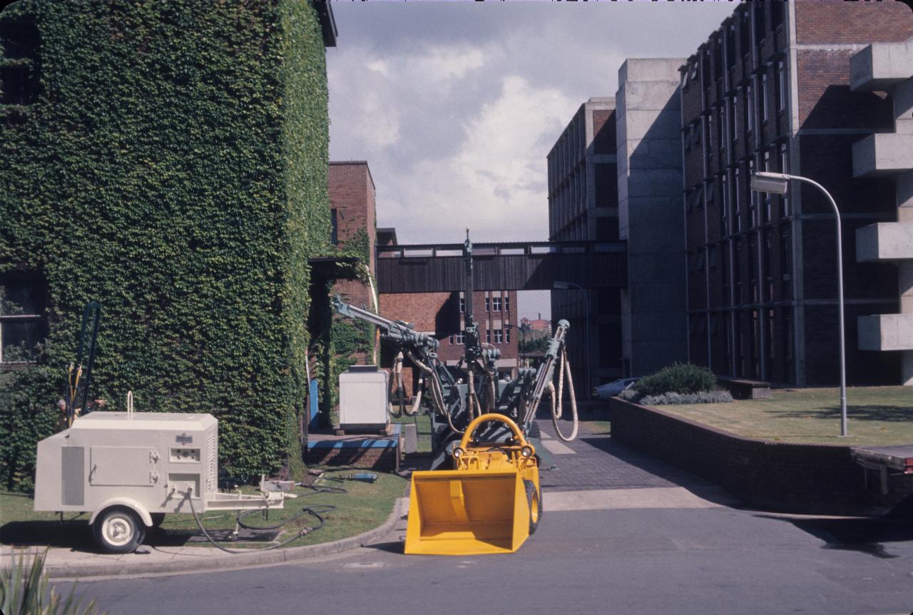 Ivy covered building on left, mining machinery beside it