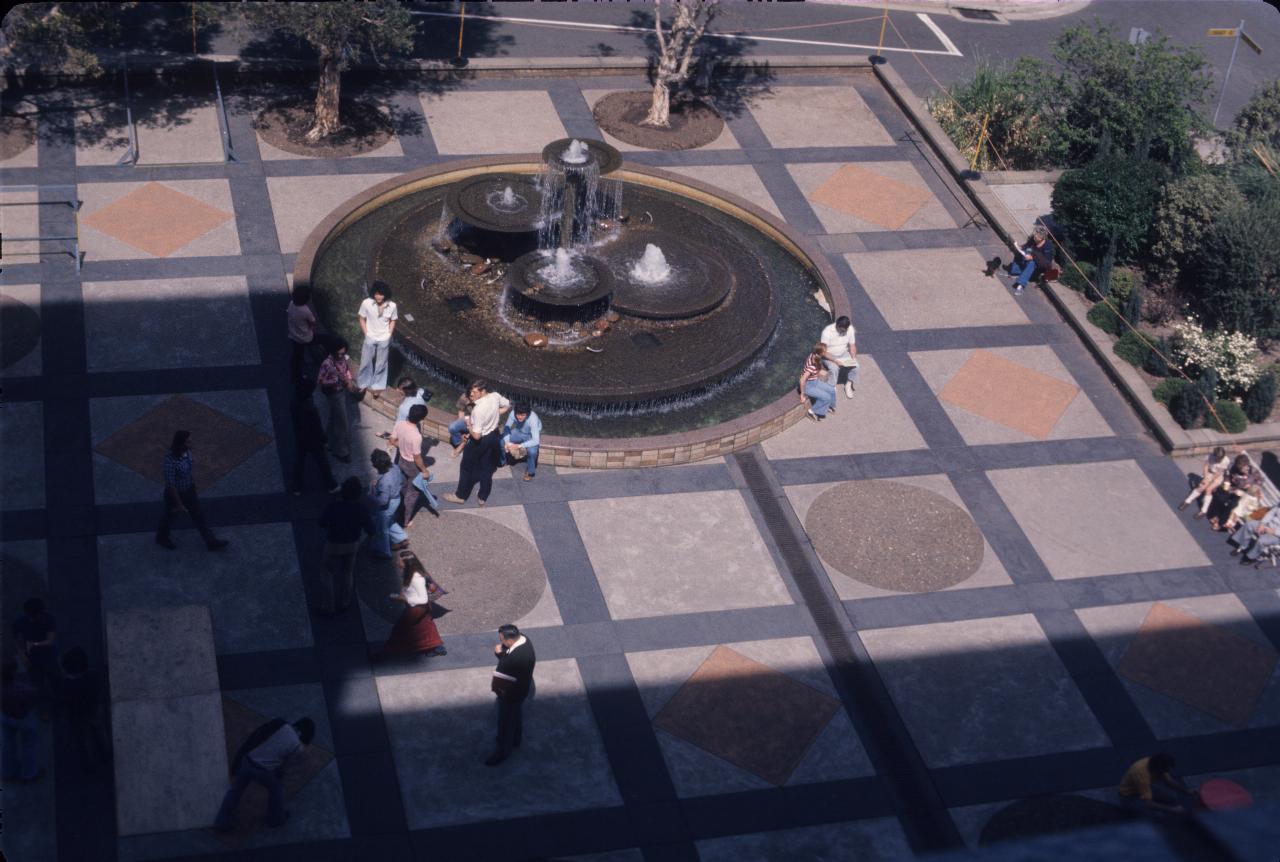 Plaza with fountain, a few people and a wooden ramp