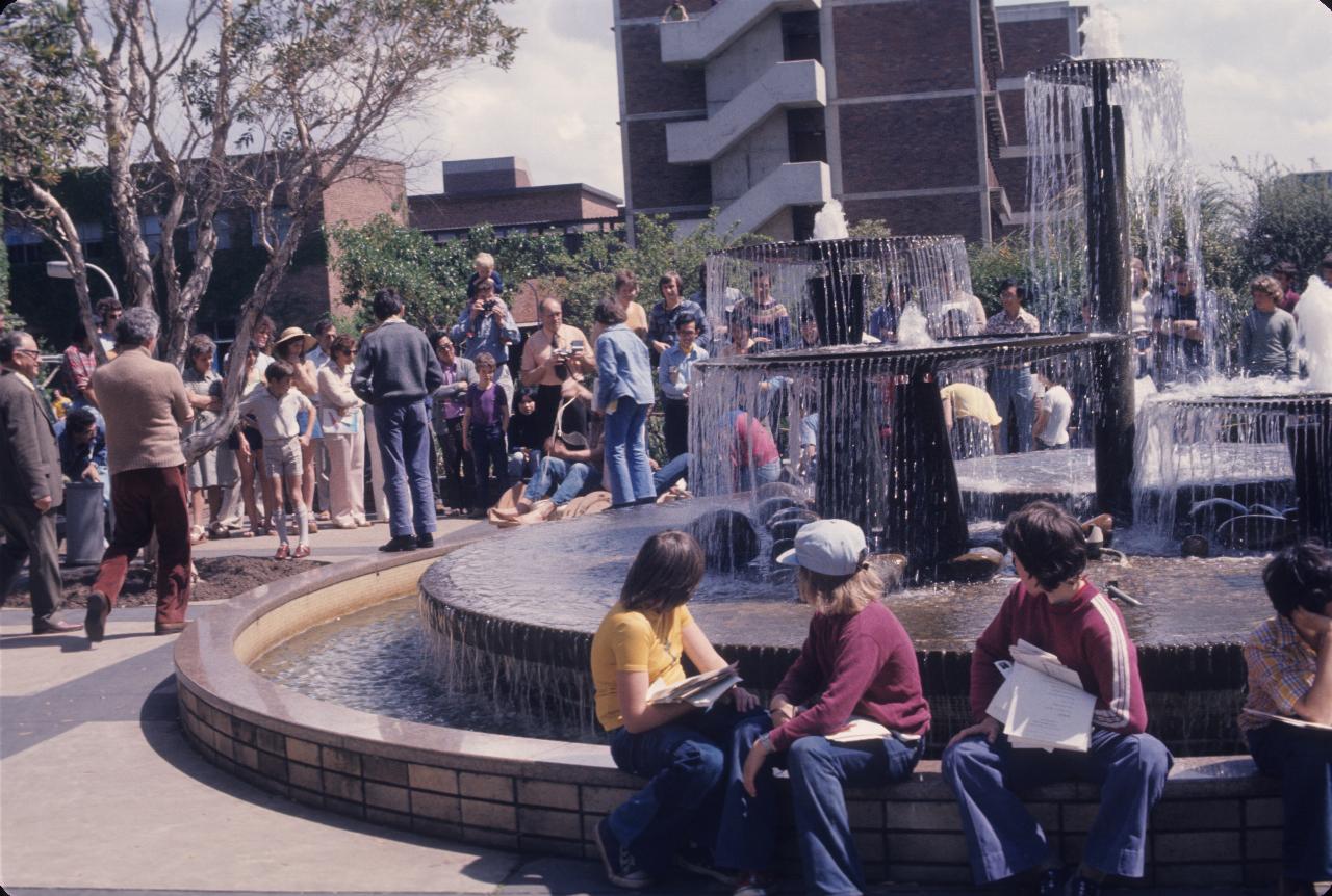 People gathered around fountain watching contestants