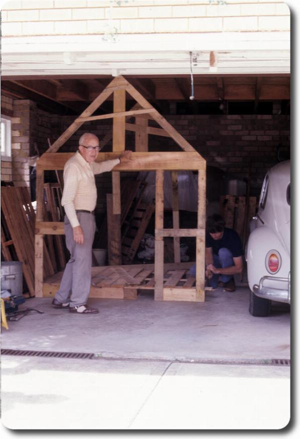 Two men in garage assembling a wooden frame