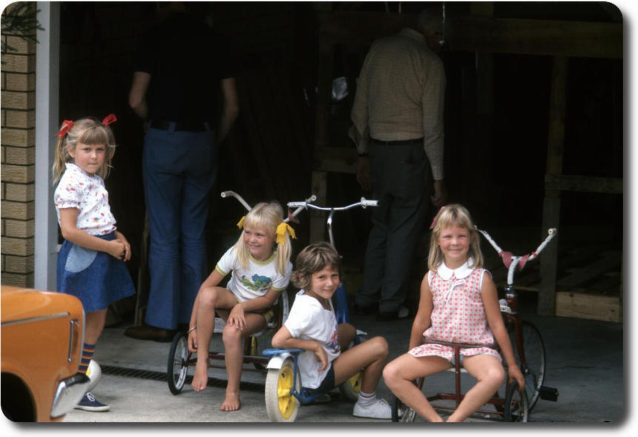 $ children in front of garage with wooden frame assembly