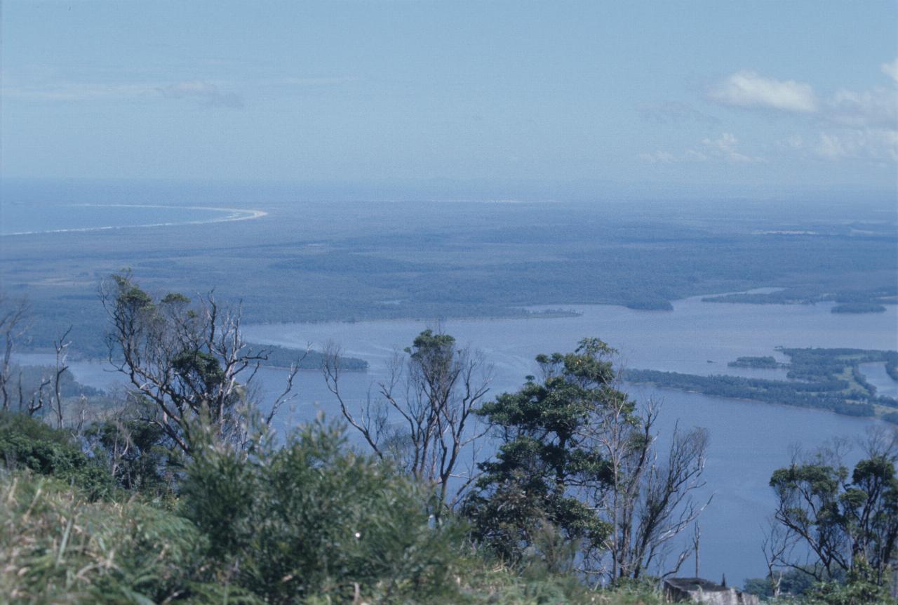 View from hill overlooking a lake and crescent shaped sandy beach