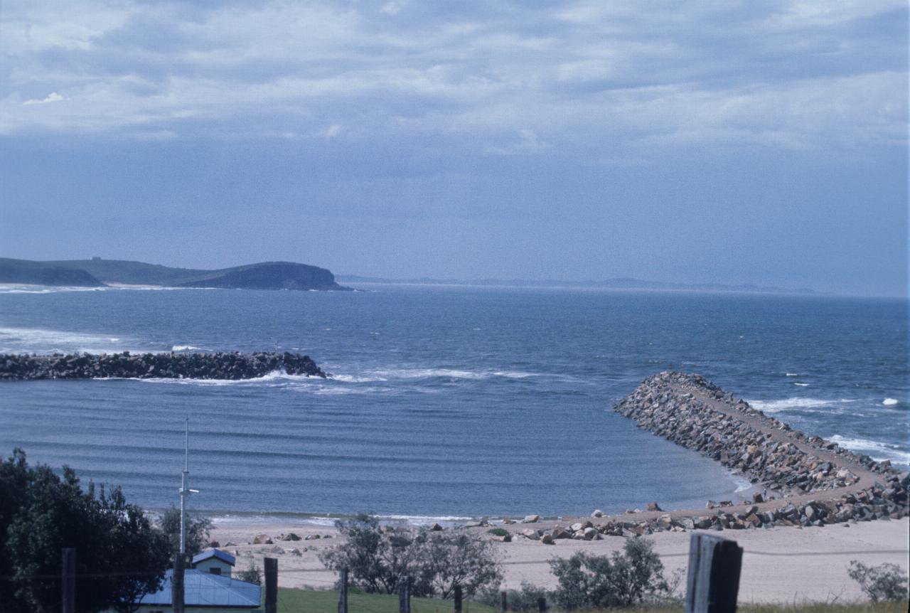 Breakwater at river mouth, then headland and distant land