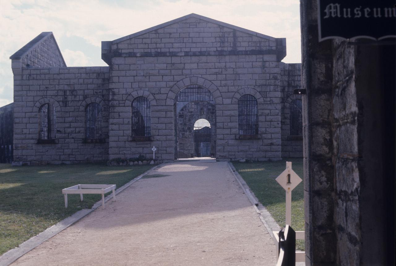 Stone building, with bars on windows, no roof, in a courtyard