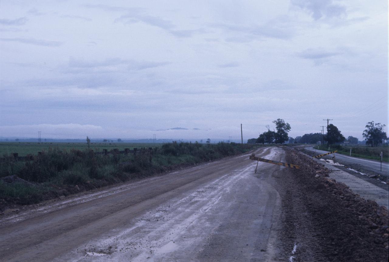 Distant fog in front of just visible mountains in distance, road works in foreground